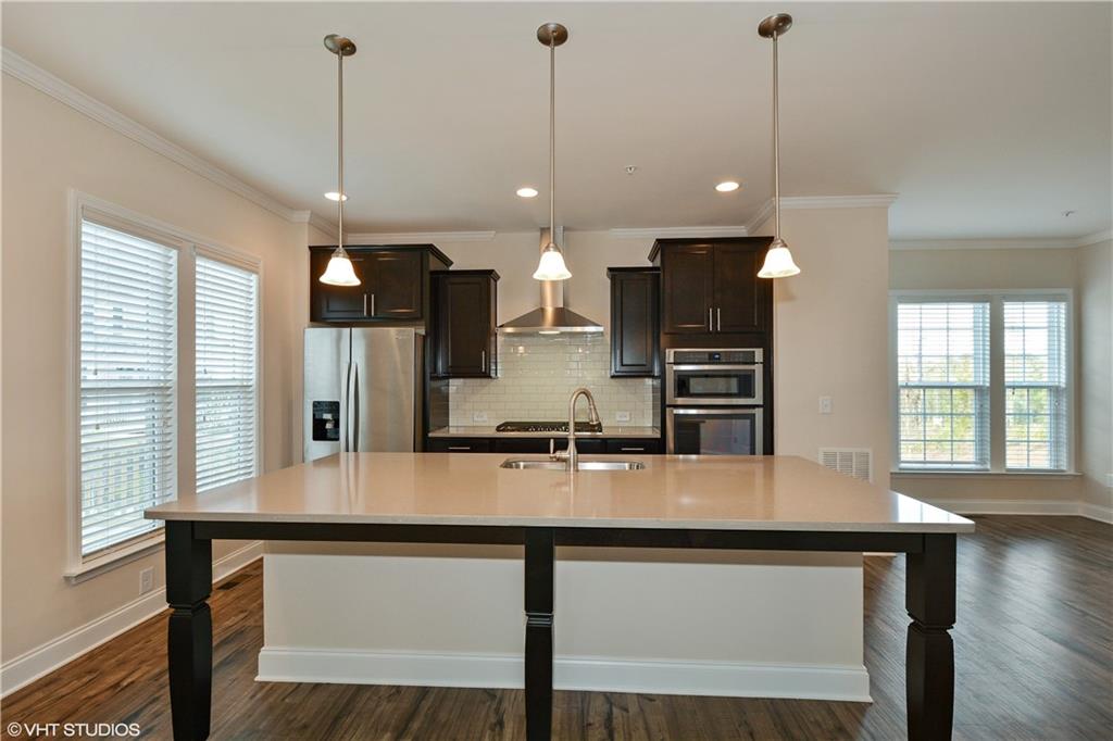 200 Braeden Way Alpharetta, GA 30009 - Photo 6 of 52 a large kitchen with kitchen island a sink table and chairs