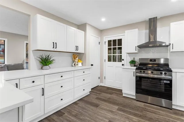 a kitchen with cabinets stainless steel appliances a sink and wooden floor