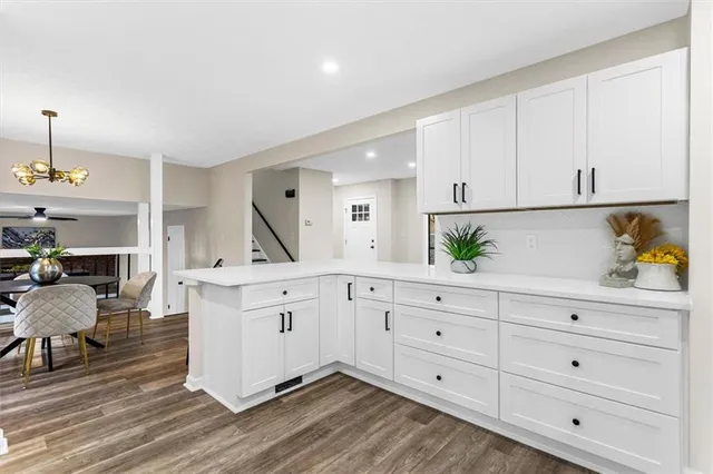 a view of an empty room with wooden floor fireplace and a window