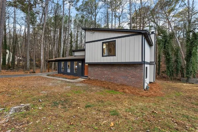 a view of a house with backyard and trees