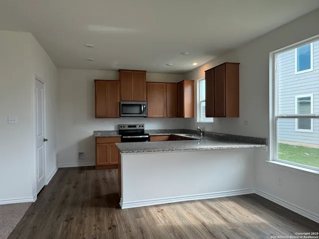 a kitchen with stainless steel appliances granite countertop a stove a sink and a refrigerator