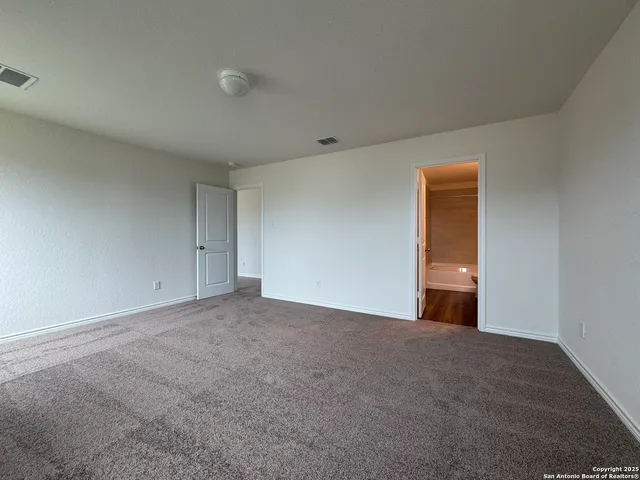 a view of an empty room and chandelier fan