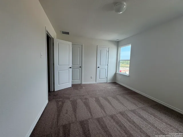 a view of empty room with window and refrigerator