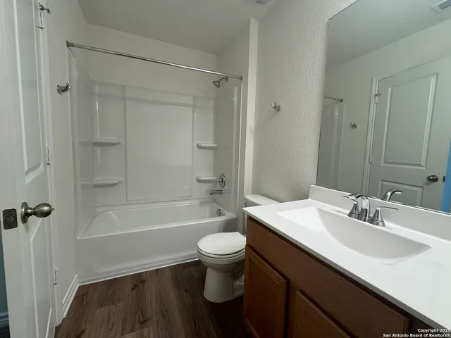 a bathroom with a sink a toilet a mirror a bathtub and shower