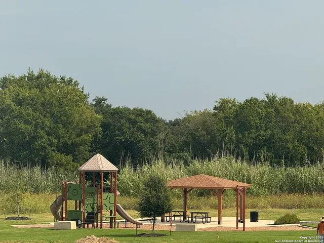 a view of a lake with a table and chairs under an umbrella