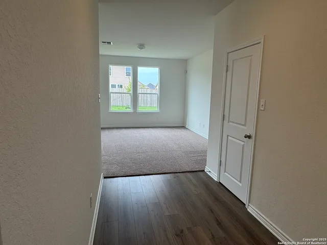 a view of a room with wooden floor and window