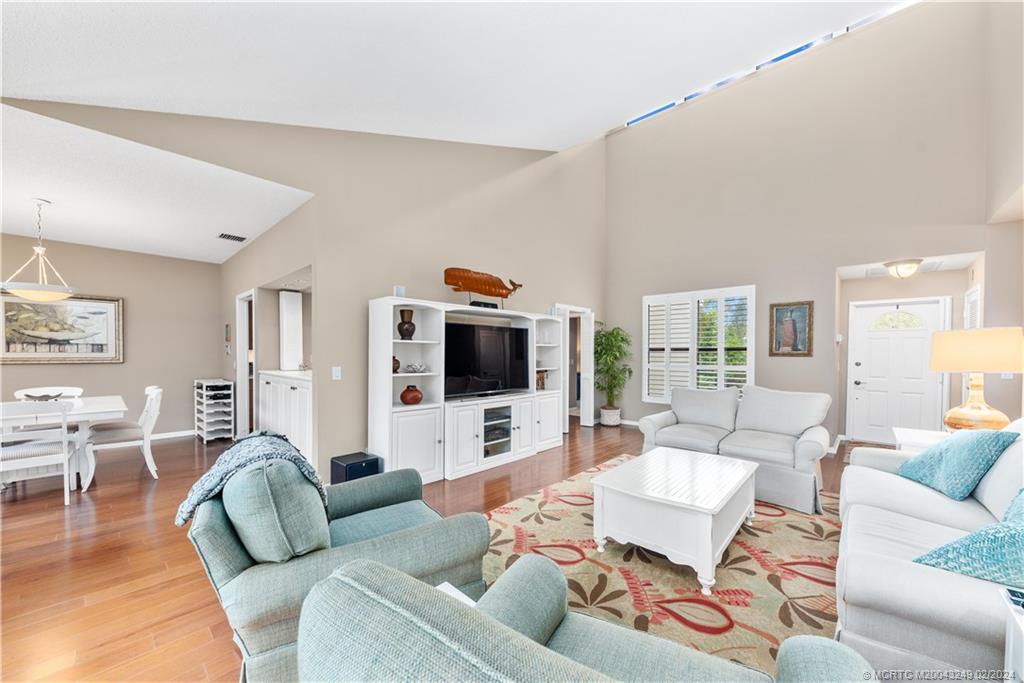 a living room with furniture flat screen tv and wooden floor