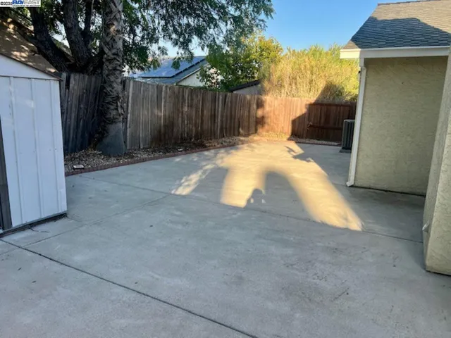 a view of backyard with tub and wooden fence