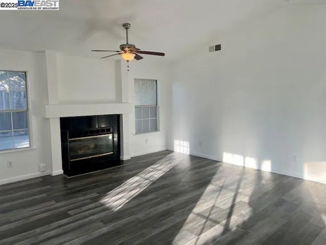 a view of empty room with wooden floor and fireplace