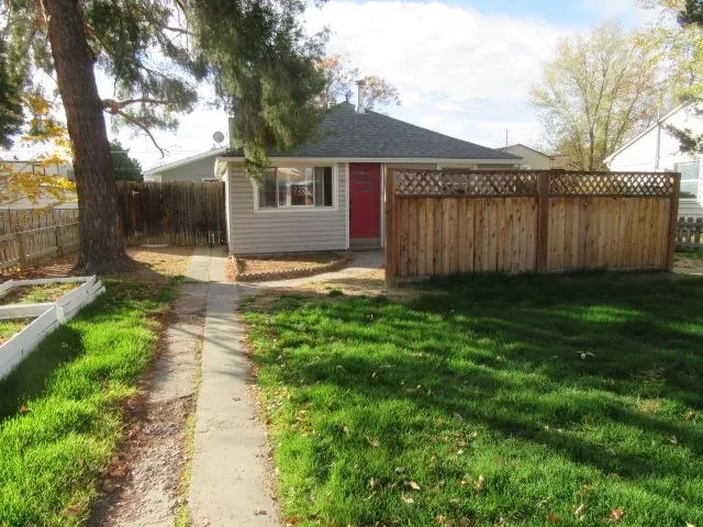 a view of a house with a yard and large tree
