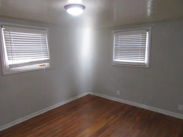 an empty room with wooden floor and a window