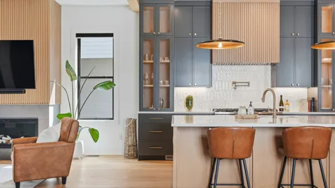 a kitchen with stainless steel appliances granite countertop a table chairs in it and wooden floors