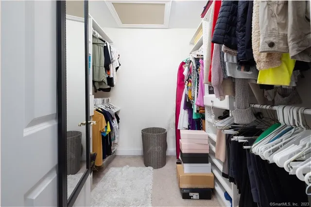 a view of walk in closet with clothes and shoes