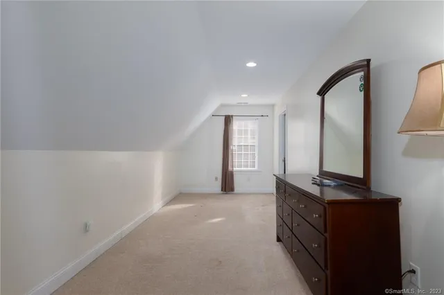a view of an empty room with window and mirror