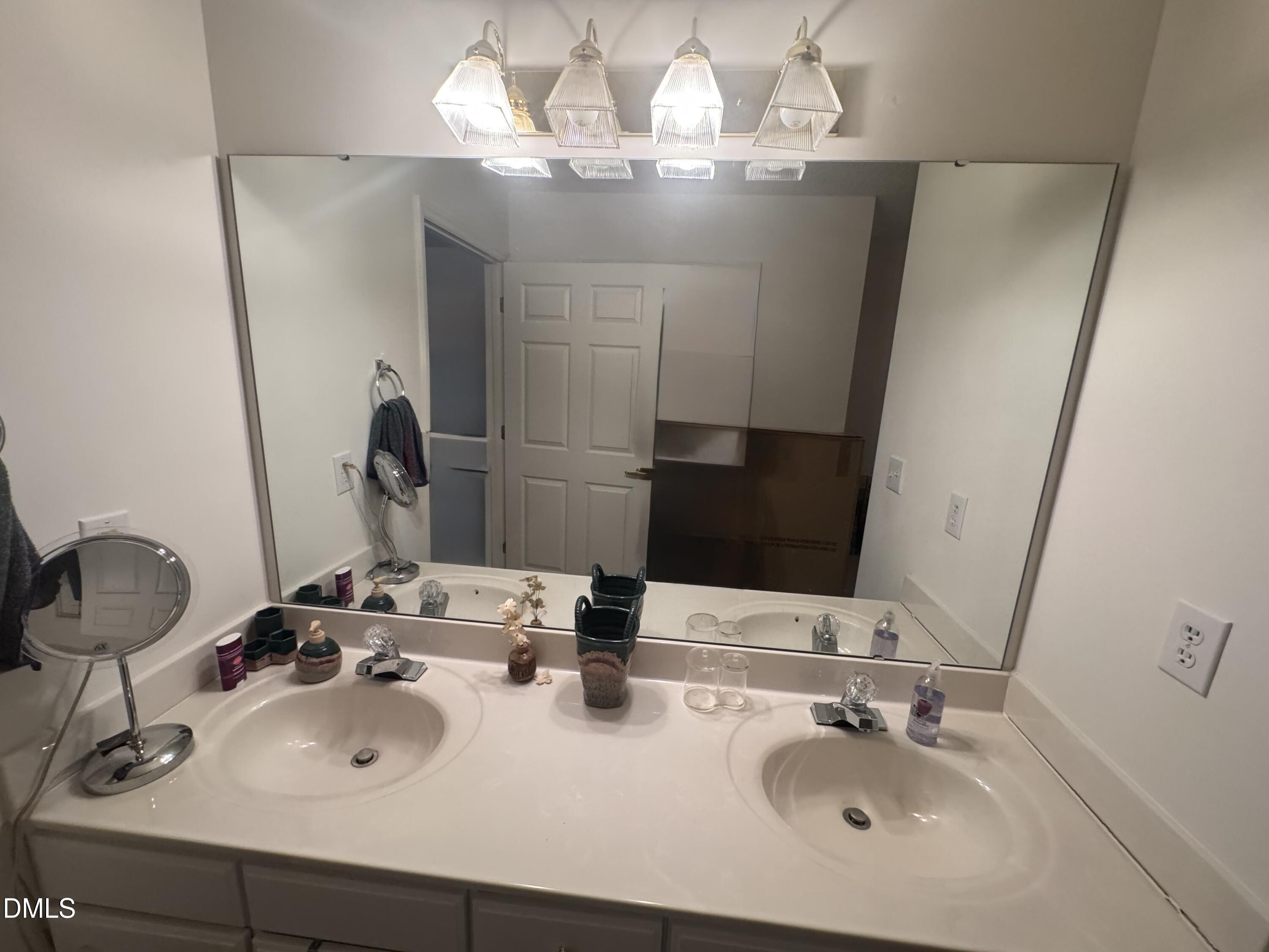 11221 Avocet Lane, Unit 102 Raleigh, NC 27617 - Photo 13 of 14 a bathroom with double vanity sinks and a mirror
