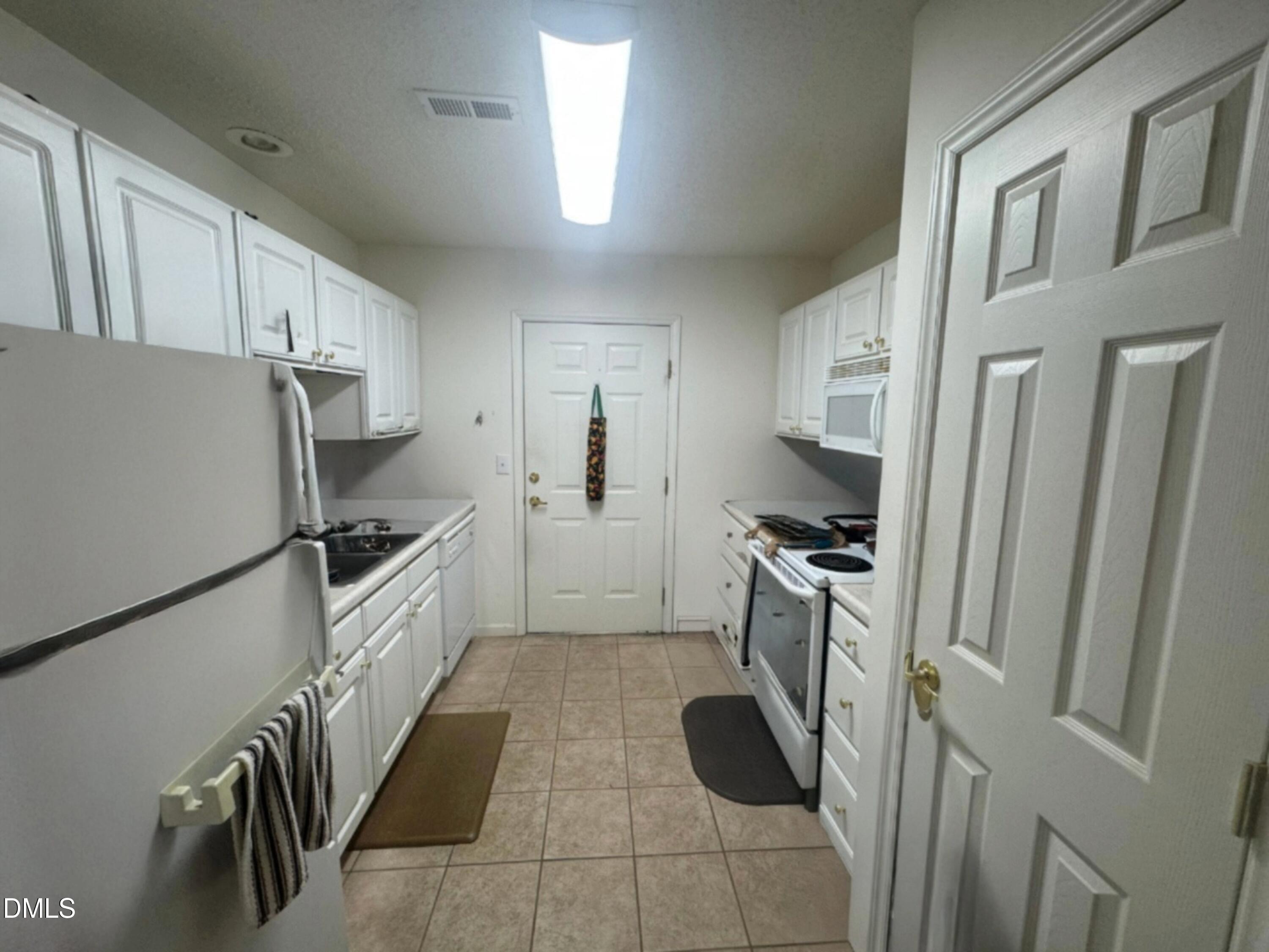 11221 Avocet Lane, Unit 102 Raleigh, NC 27617 - Photo 4 of 14 a kitchen with granite countertop a refrigerator a sink a stove a microwave and island