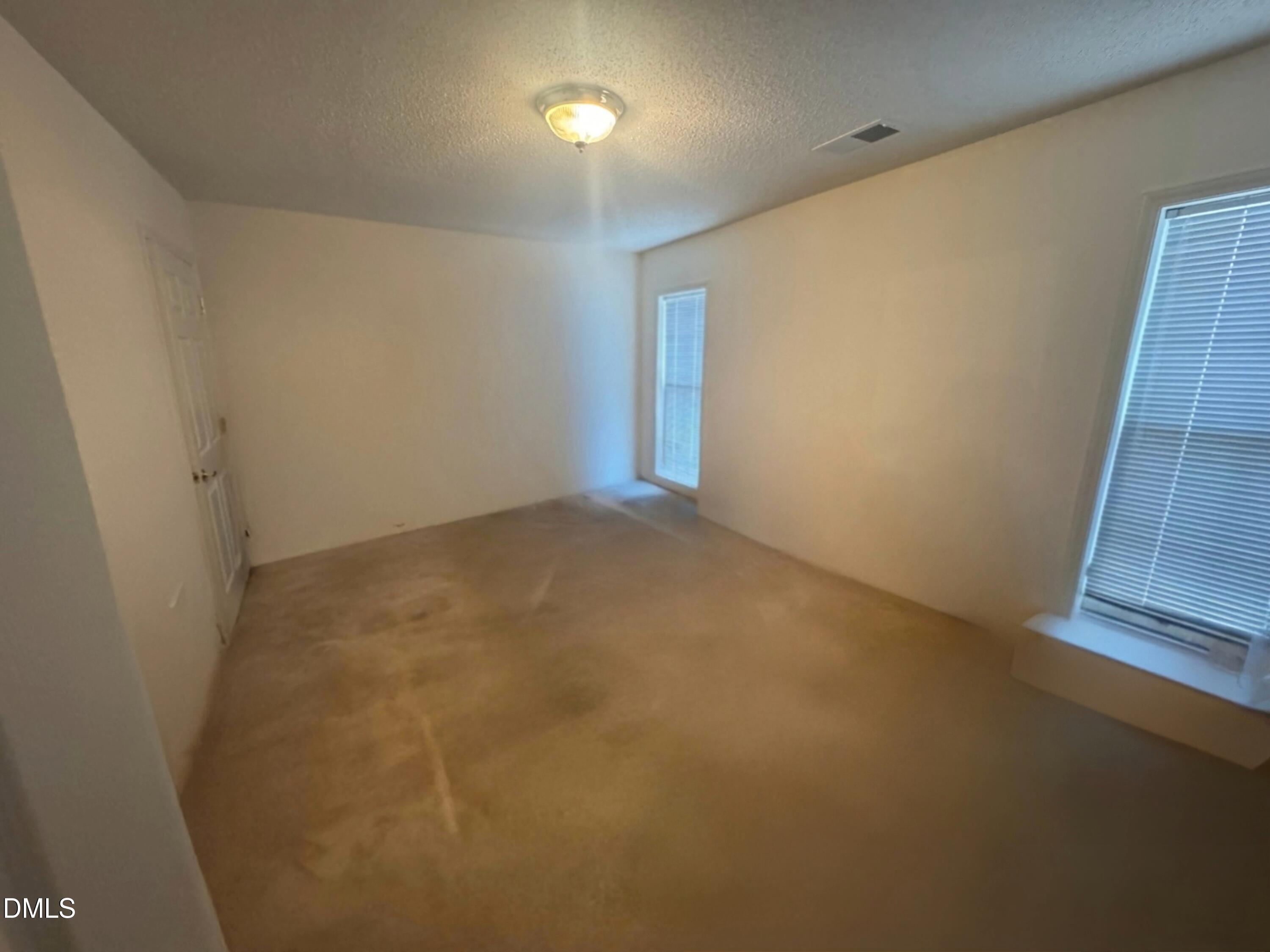 11221 Avocet Lane, Unit 102 Raleigh, NC 27617 - Photo 9 of 14 an empty room with wooden floor and windows