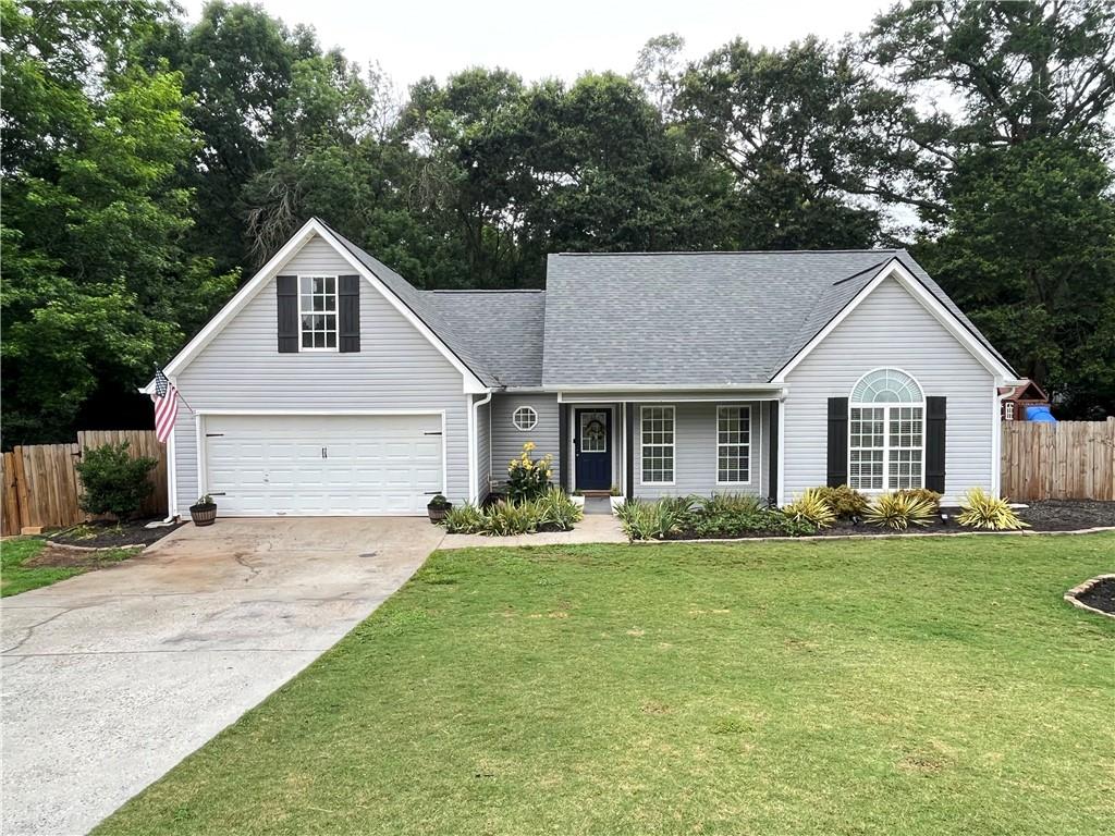 a front view of a house with a garden and trees