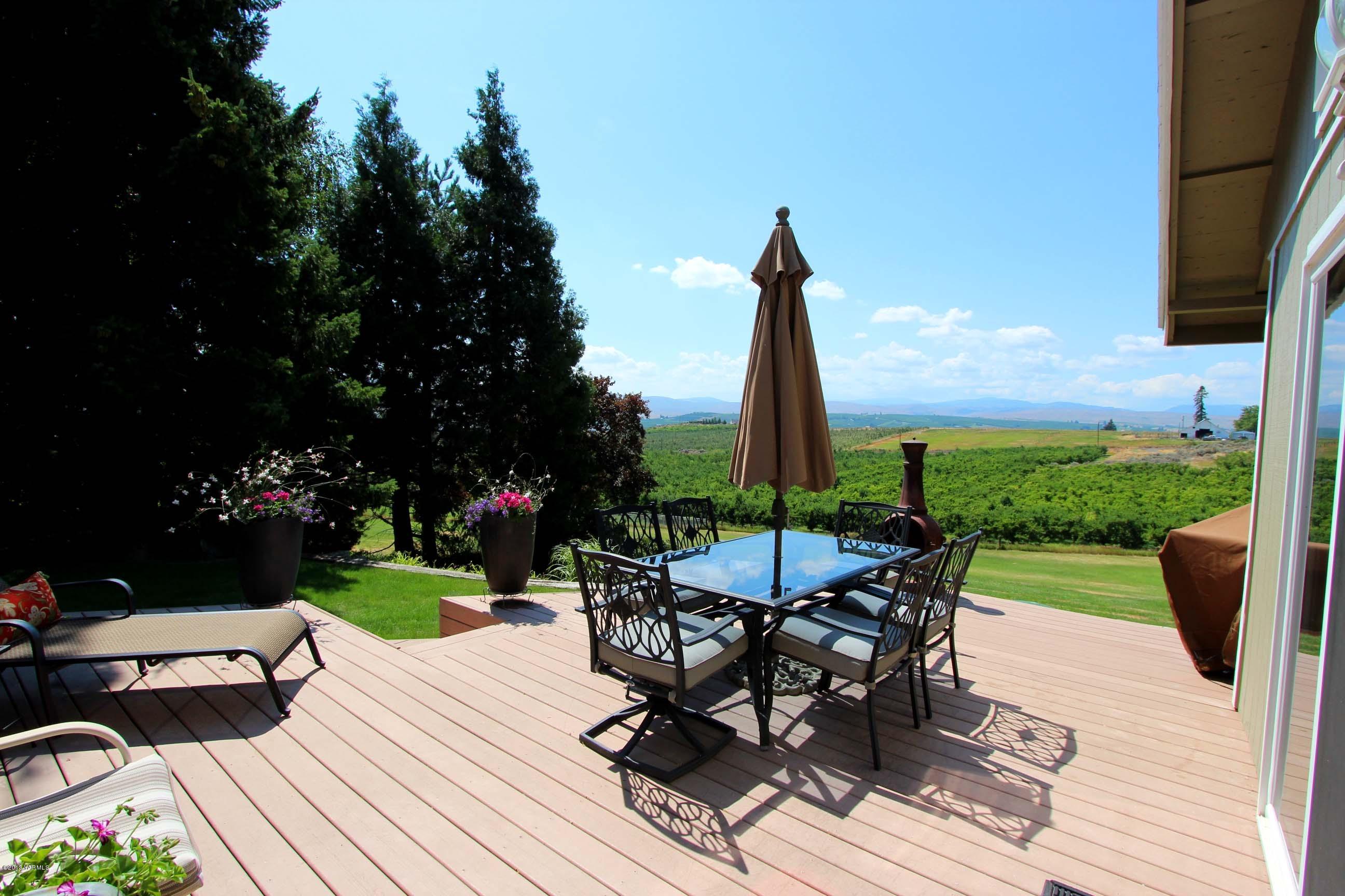170 Wilcox Road Cowiche, WA 98923 - Photo 28 of 39 a view of a patio with table and chairs potted plants with wooden floor and fence