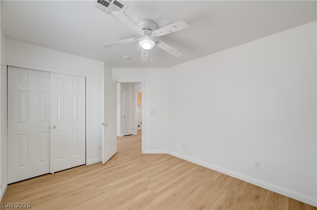 8918 Houston Ridge Avenue Las Vegas, NV 89178 - Photo 24 of 35 A versatile space features modern laminate flooring and a ceiling fan, offering comfortable living.