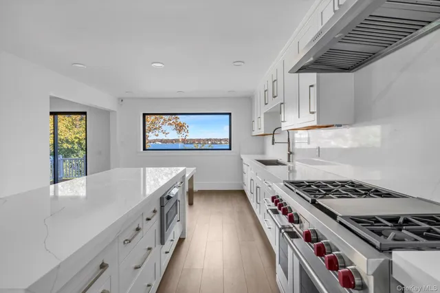 a kitchen with stainless steel appliances granite countertop a stove a sink dishwasher and cabinets with wooden floor