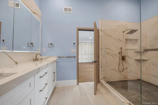 a bathroom with a granite countertop sink mirror and shower