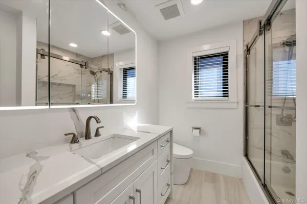 a bathroom with a sink a toilet and shower