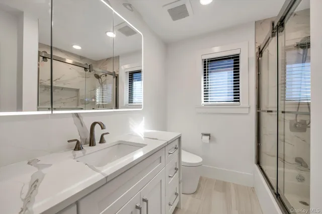 a bathroom with a sink a toilet and shower