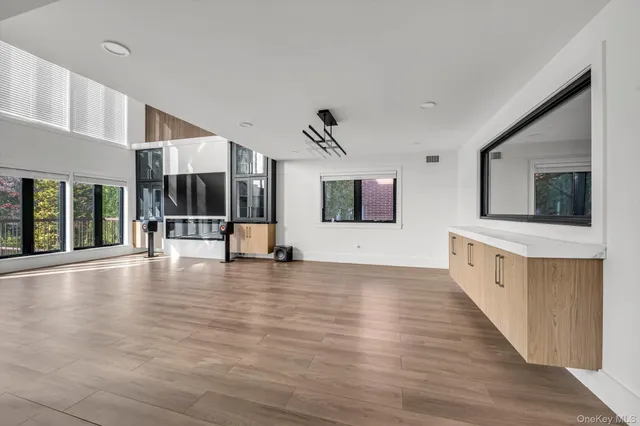 a view of a living room with wooden floor and flat screen tv