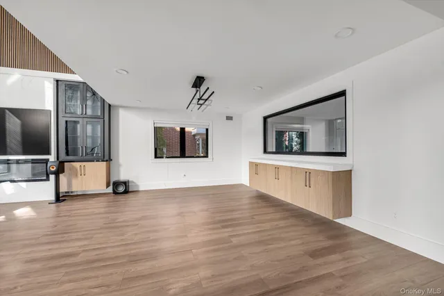 a view of a big room with wooden floor and windows