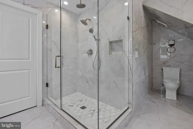 a bathroom with a granite countertop sink toilet and mirror