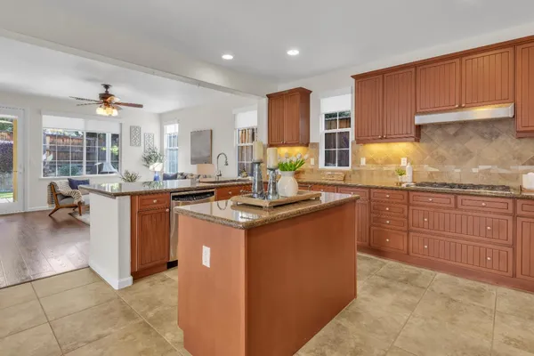 a kitchen with granite countertop a sink and a stove top oven
