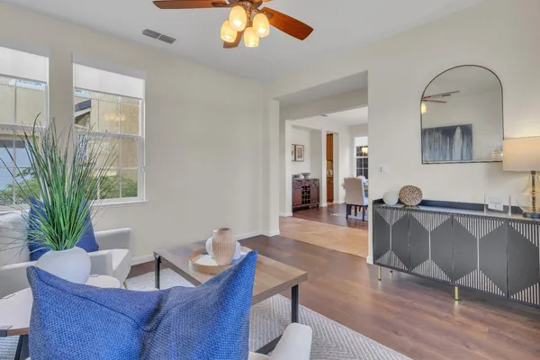 a dining room with furniture a chandelier and wooden floor