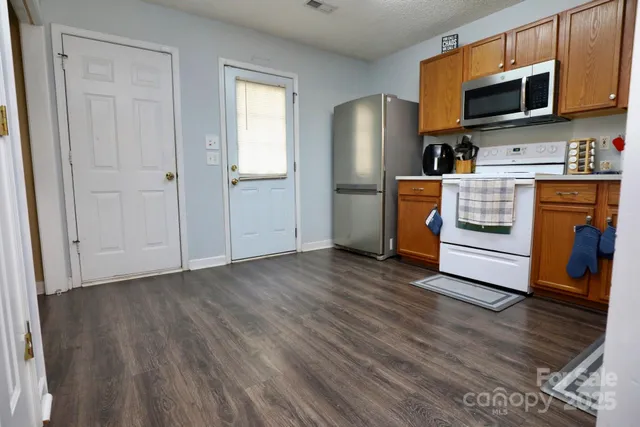 a kitchen with stainless steel appliances granite countertop a refrigerator microwave and sink