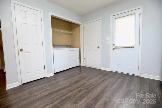 a view of an empty room with wooden floor and closet