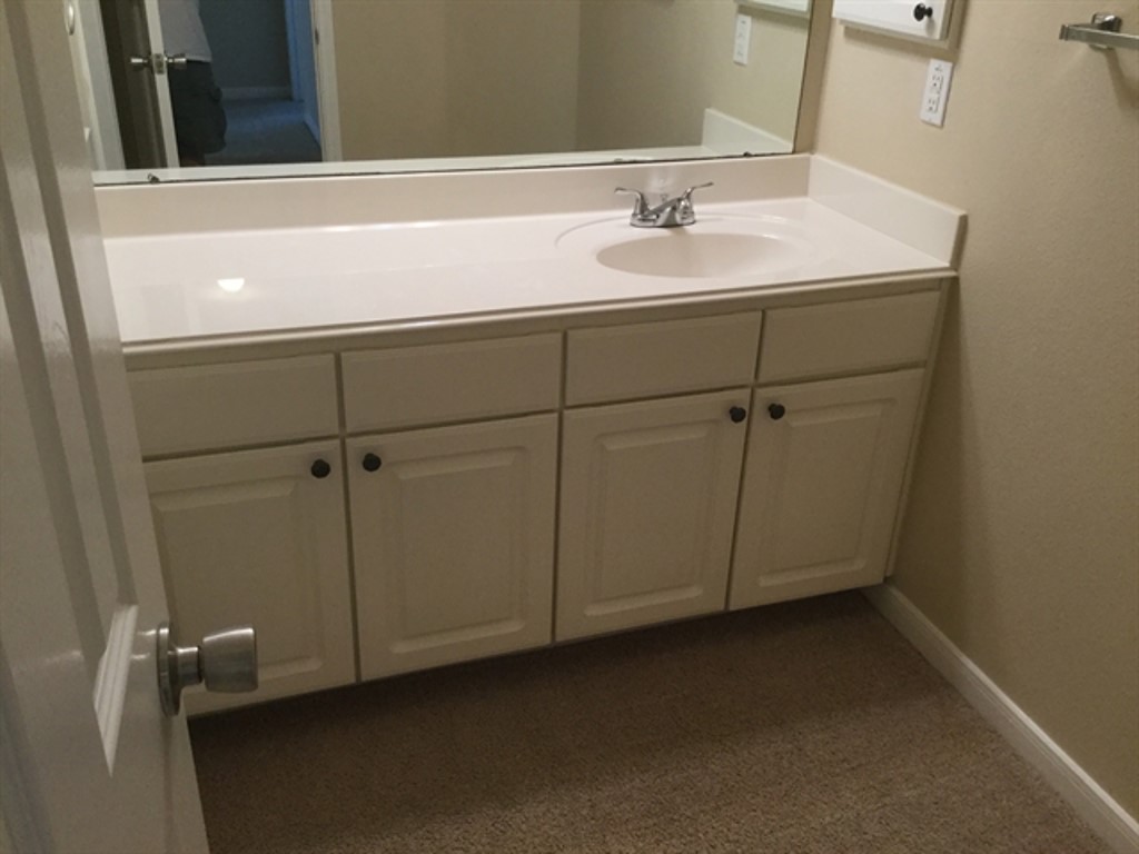 9830 Wing Street Conroe, TX 77385 - Photo 15 of 22 a bathroom with a sink and cabinets