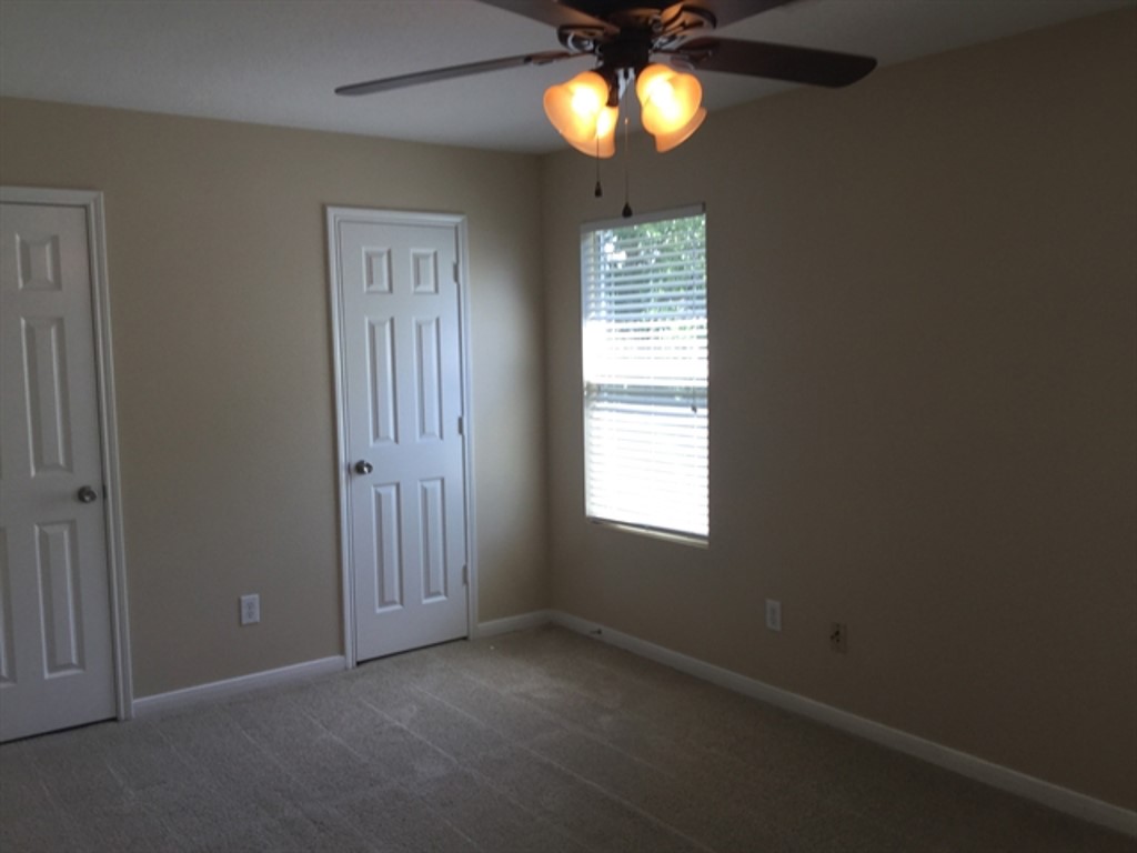 9830 Wing Street Conroe, TX 77385 - Photo 17 of 22 an empty room with windows and a chandelier fan