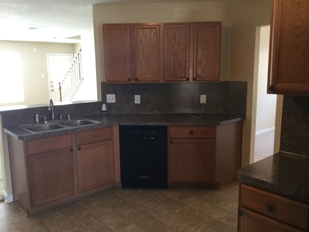 9830 Wing Street Conroe, TX 77385 - Photo 2 of 22 a kitchen with granite countertop a sink cabinets and a stove top oven