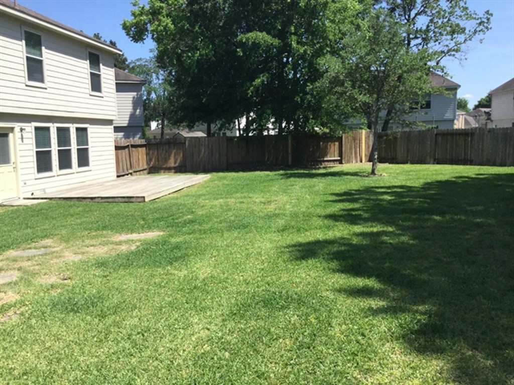 9830 Wing Street Conroe, TX 77385 - Photo 21 of 22 a view of a house with a backyard