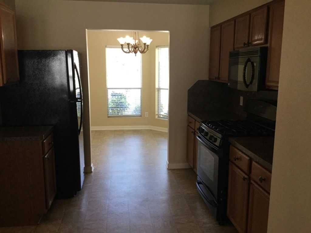 9830 Wing Street Conroe, TX 77385 - Photo 3 of 22 a kitchen with stainless steel appliances a refrigerator and a stove top oven