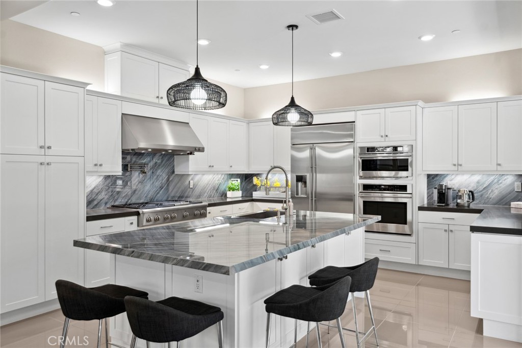 131 Spiral Irvine, CA 92618 - Photo 14 of 39 a kitchen with stainless steel appliances granite countertop a stove a sink and a refrigerator