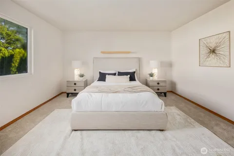 a bedroom with a bed and a large window