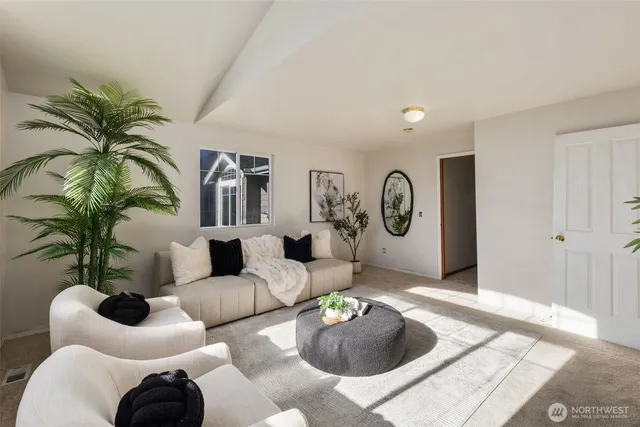 a living room with furniture potted plant and kitchen view
