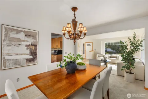 a dining room with furniture potted plants and wooden floor
