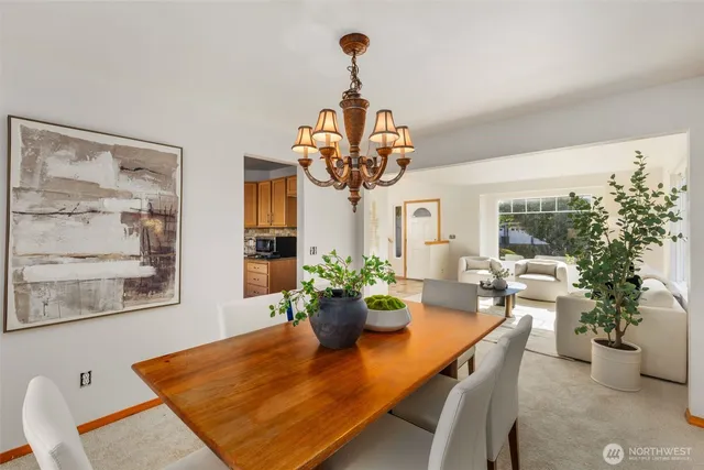 a dining room with furniture potted plants and wooden floor