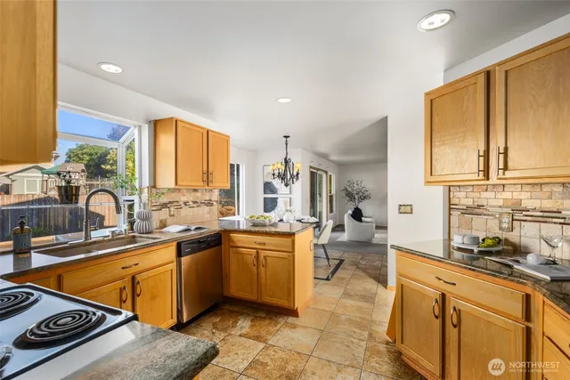 a kitchen with stainless steel appliances a sink a stove and a refrigerator