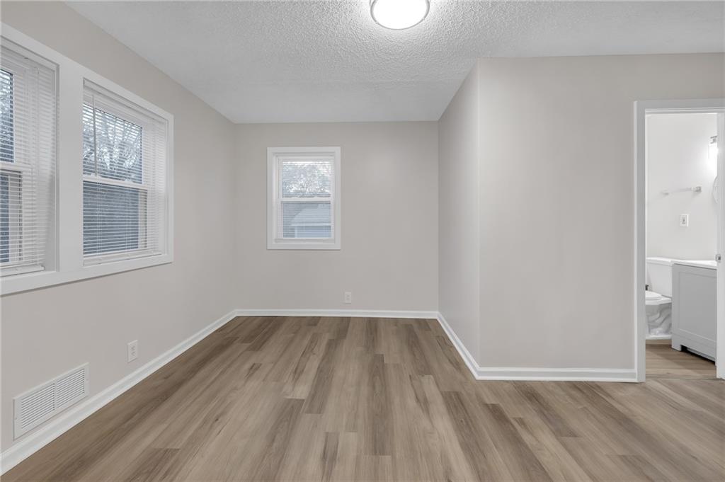 1683 Candler Road Decatur, GA 30032 - Photo 16 of 24 a view of an empty room with wooden floor and a window