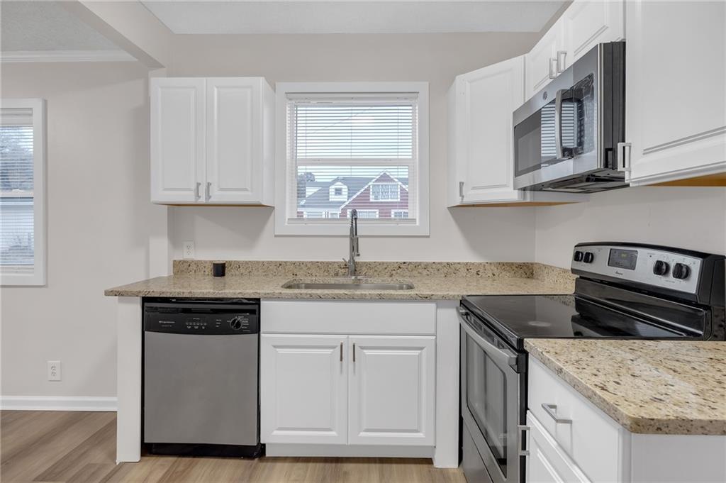 1683 Candler Road Decatur, GA 30032 - Photo 8 of 24 a kitchen with stainless steel appliances granite countertop a sink stove and cabinets