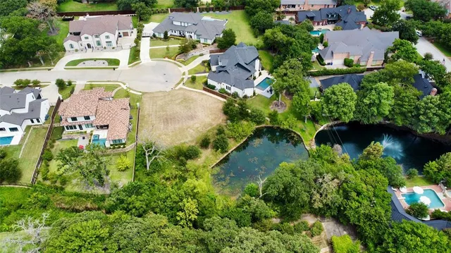 an aerial view of residential houses with outdoor space and trees all around