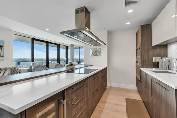 a large kitchen with granite countertop a sink and dishwasher a stove top oven with wooden floor